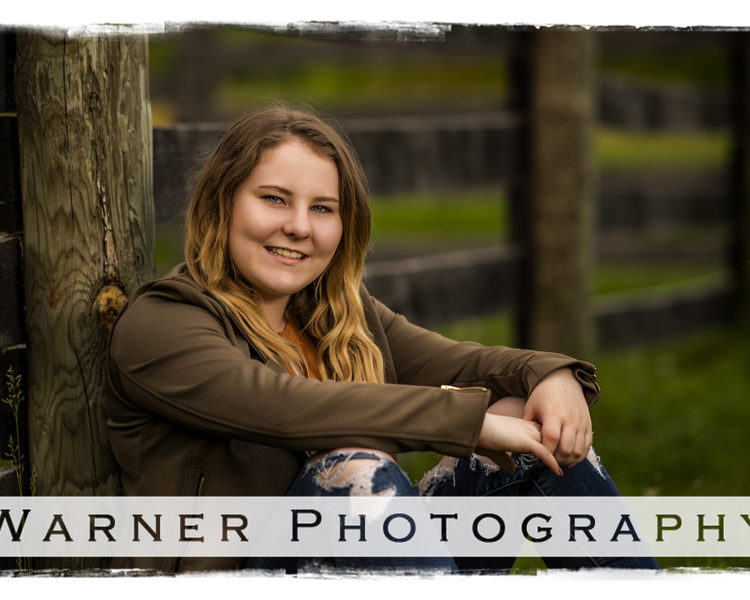 Senior portrait of Jessica by a rustic fence at Chippewa Nature Center in Midland Michigan