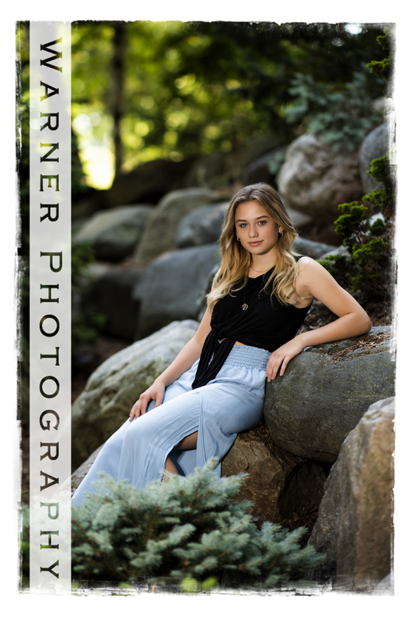 A portrait of Dow High School Senior Isabella at Dow Gardens on the rocks