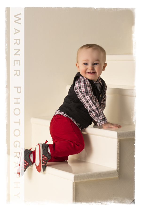 Childrens portrait of Keygan on white steps crawling red pants