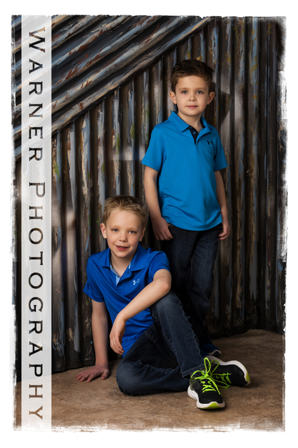 studio portrait of Matthew and Trenton with the metal wall blue shirts studio