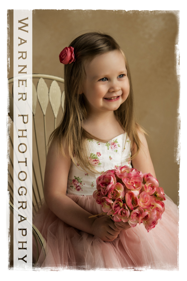 3rd Birthday pictue of Evie at the studio with pink roses and a white chair