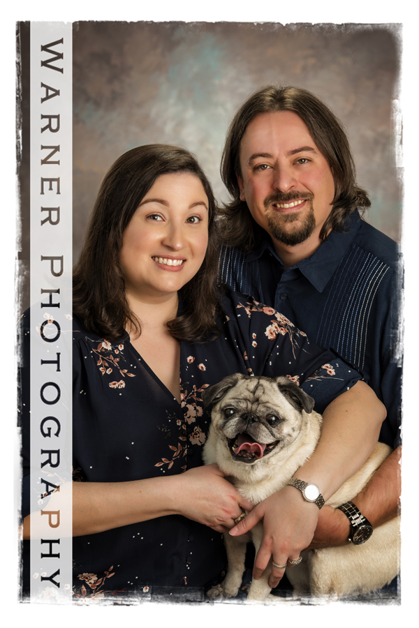 Studio portrait of David and Elena with their pug dog Stella