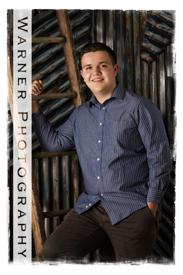 Studio portrait of Josh for his Back to School session with a metal wall and a ladder