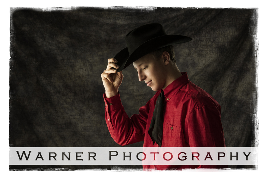 Studio portrait of Dow High School senior Tommy with his black cowboy hat and red shirt