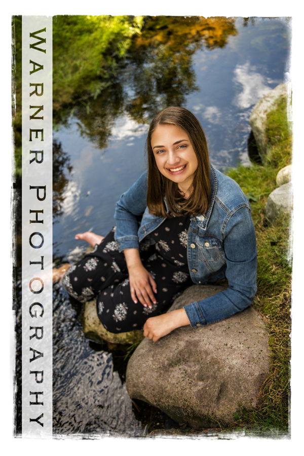outdoor portrait of Midland High School senior Alexandra at Dow Gardens in the stream with rocks
