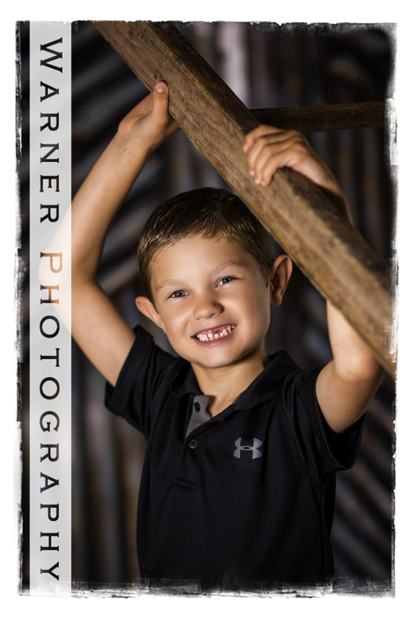 Studio portrait of Drew for his Back to School session by a wooden ladder