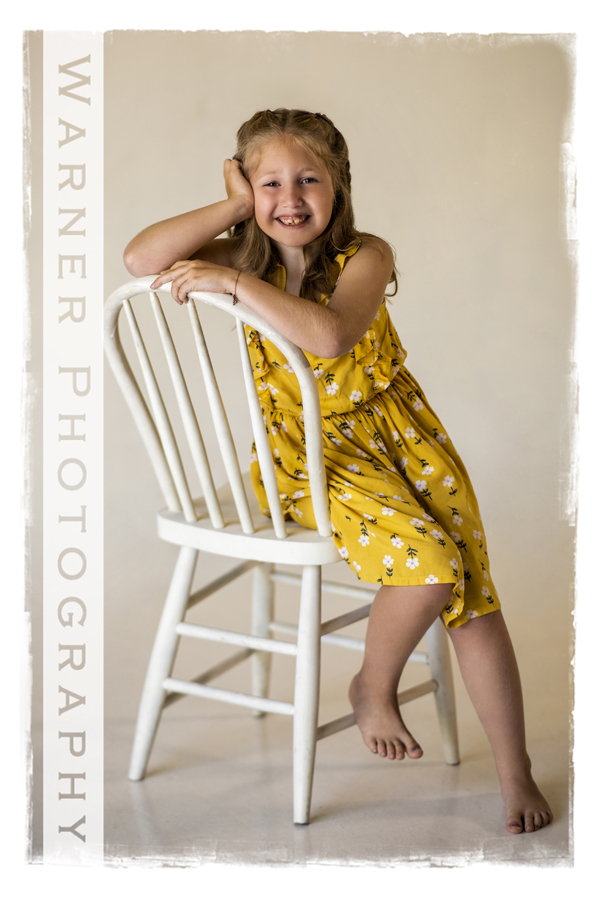 a studio portriat of Peyton for her Back to School session on a white chair