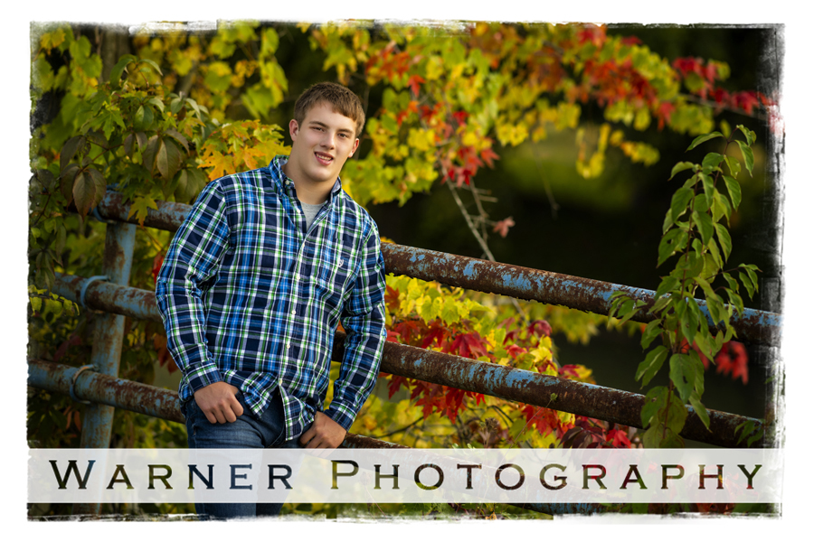 An outdoor portrait of Bullock Creek High School senior Tyler by an iron bridge and fall leaves