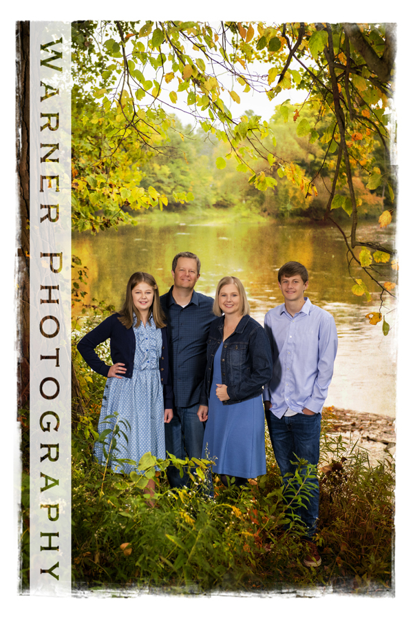 an outdoor family portrait of the Frame family at Chippewa Nature Center by the river