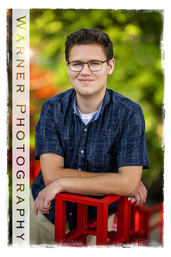 Outdoor portrait of Shepherd High School senior Hadrian at Dow Gardens by the red bridge