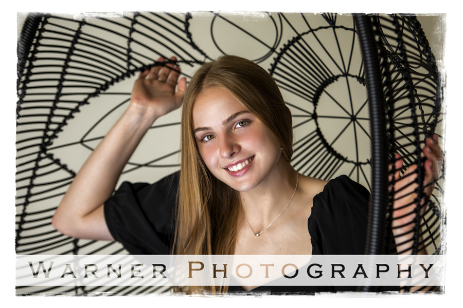 a studio portrait of Dow High School senior Lauren in a black chair