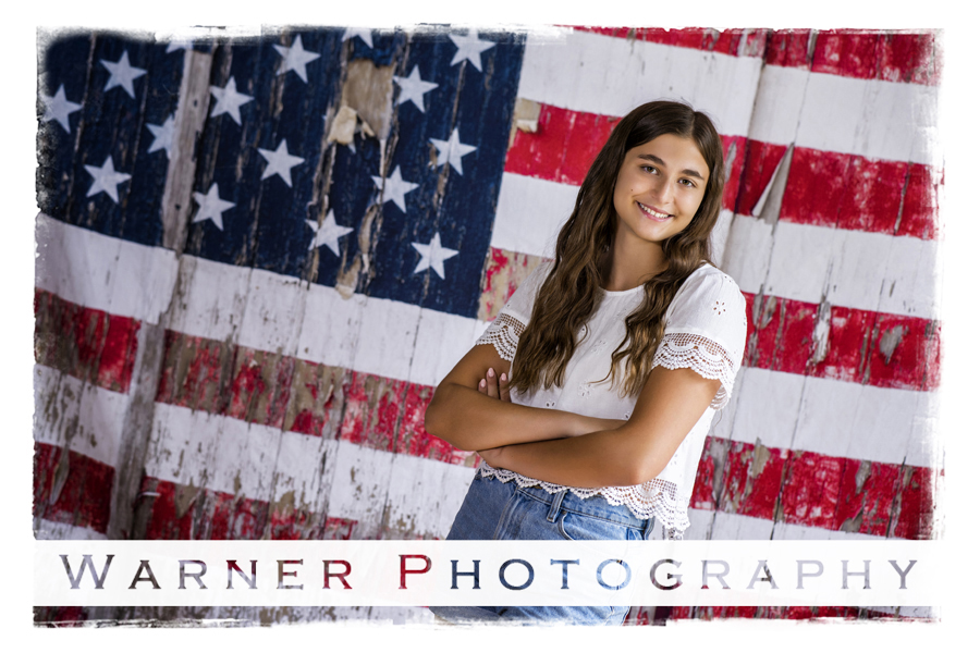 a studio portrait of Dow High senior Vivian with an american flag background