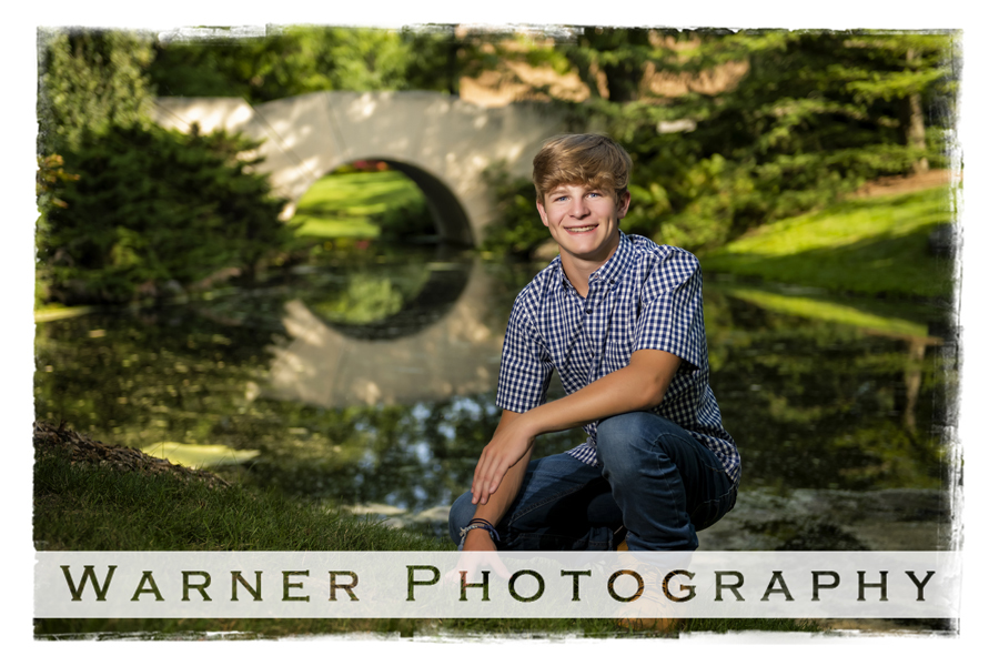 an outdoor portrait of Dow High School senior Brennan at Dow Gardens by a bridge