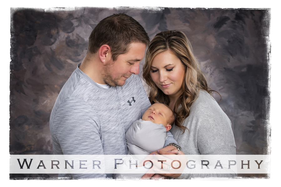 A studio portrait of newborn Jetson with his parents